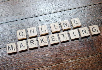 Scrabble tiles arranged to spell 'ONLINE MARKETING' on a wooden table with a textured surface.